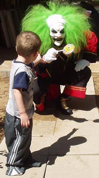 Kid reaches for sucker from Scary Clown