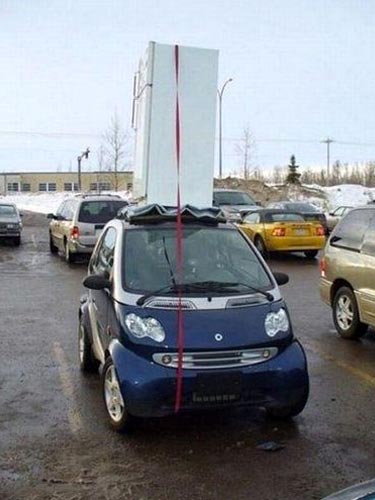 Refrigerator Strapped To The Roof Of A Smart Car