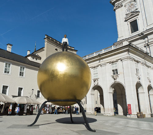 Man Standing On Top Of A Golden Ball In Salzburg