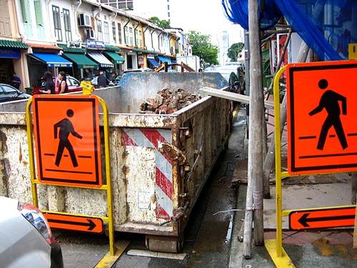 Road Work Signs Pointing Two Figures Towards Each Other